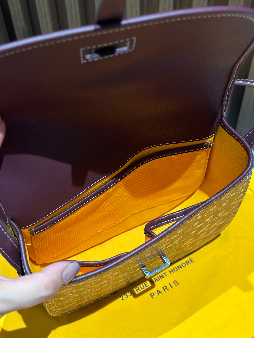 Goyard bag interior view with maroon lining and top clasp on patterned flap
