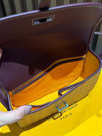 Goyard bag interior view with maroon lining and top clasp on patterned flap