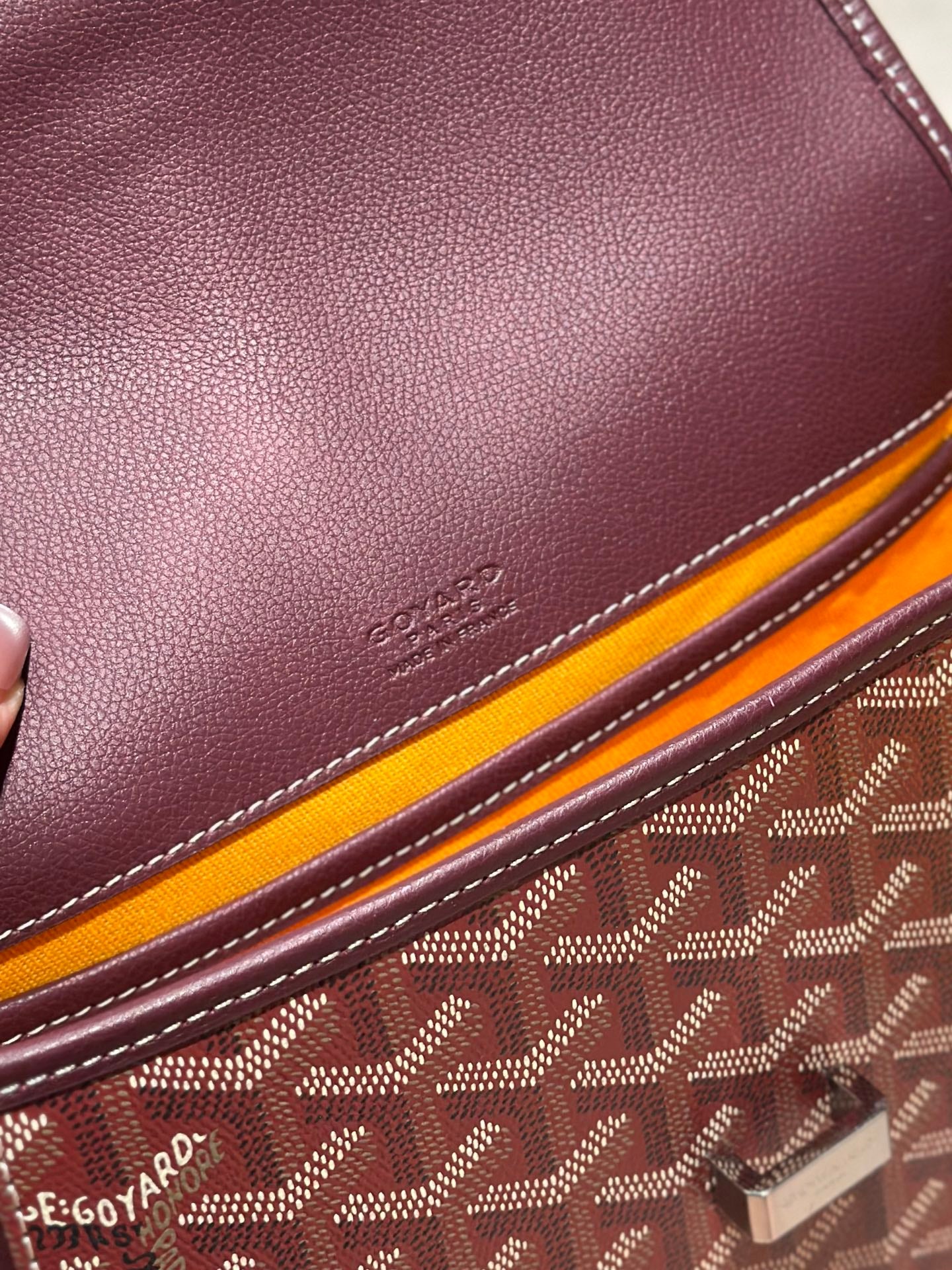 Goyard maroon leather bag panel with engraved logo, stitched edge and patterned trim