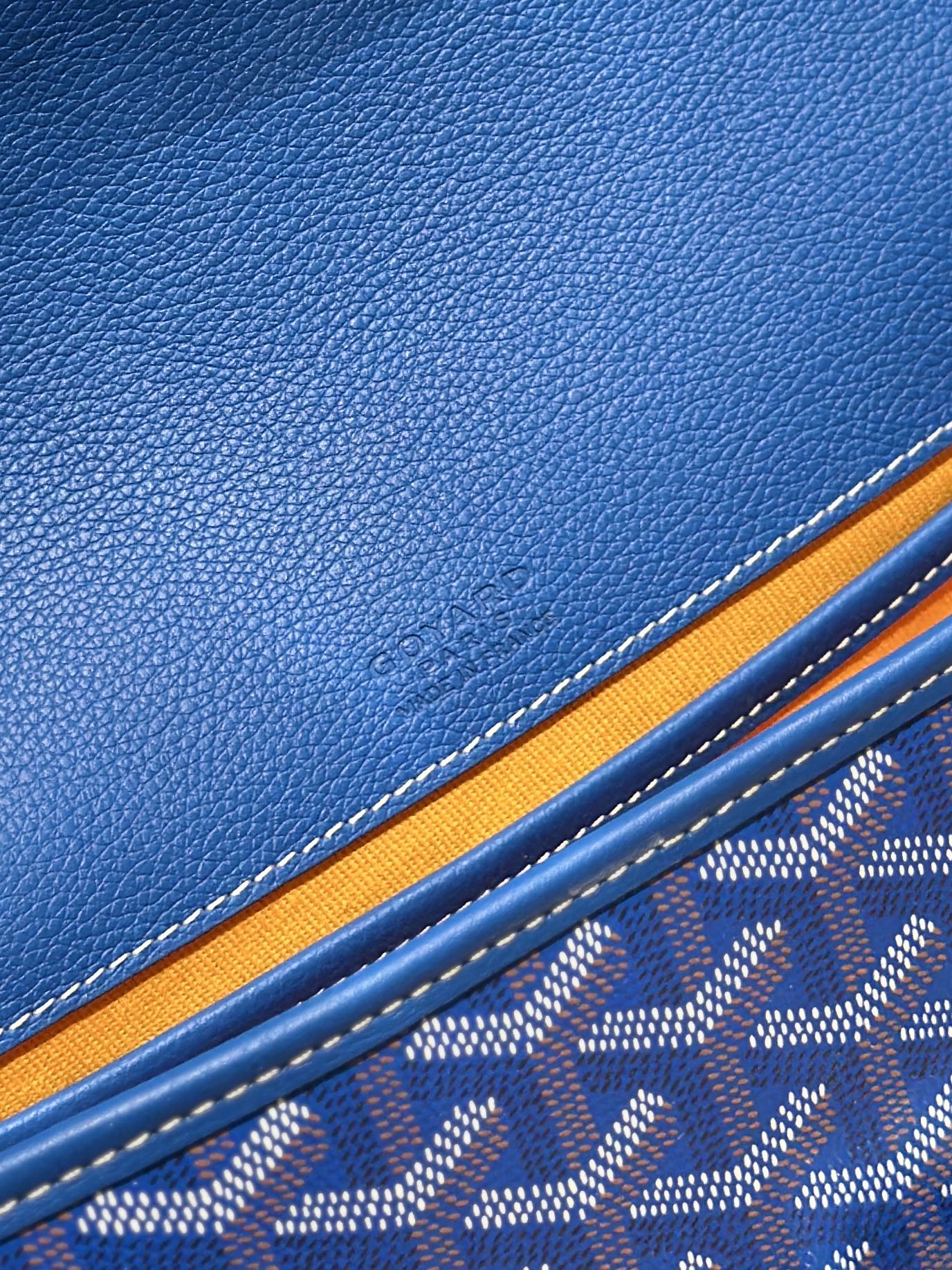 Blue leather trim and monogram fabric detail on a Goyard bag