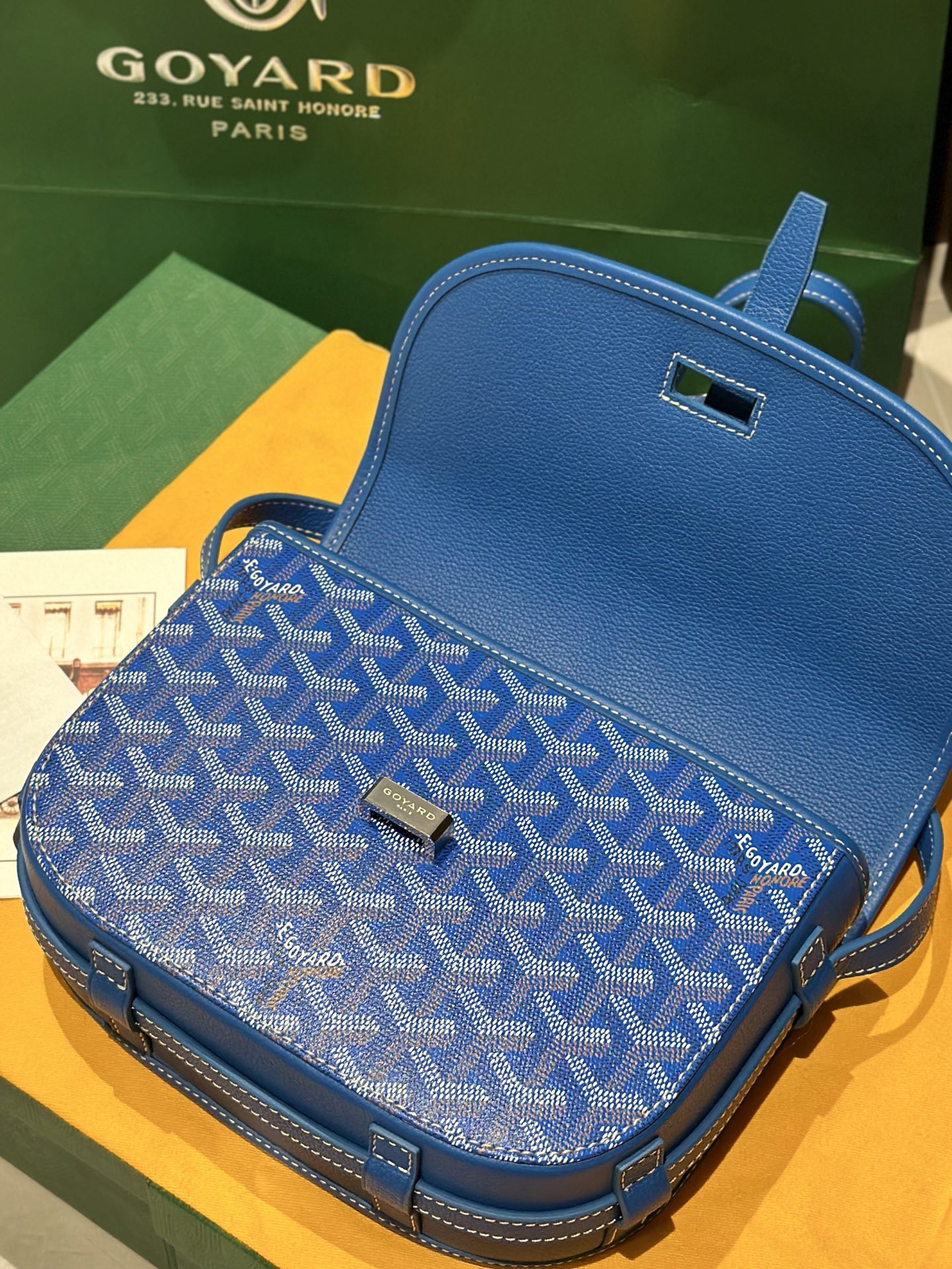 Goyard bag in blue with monogram fabric, flap closure, and leather trim details