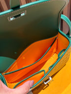 Goyard crossbody bag interior view with orange lining and leather edge trim