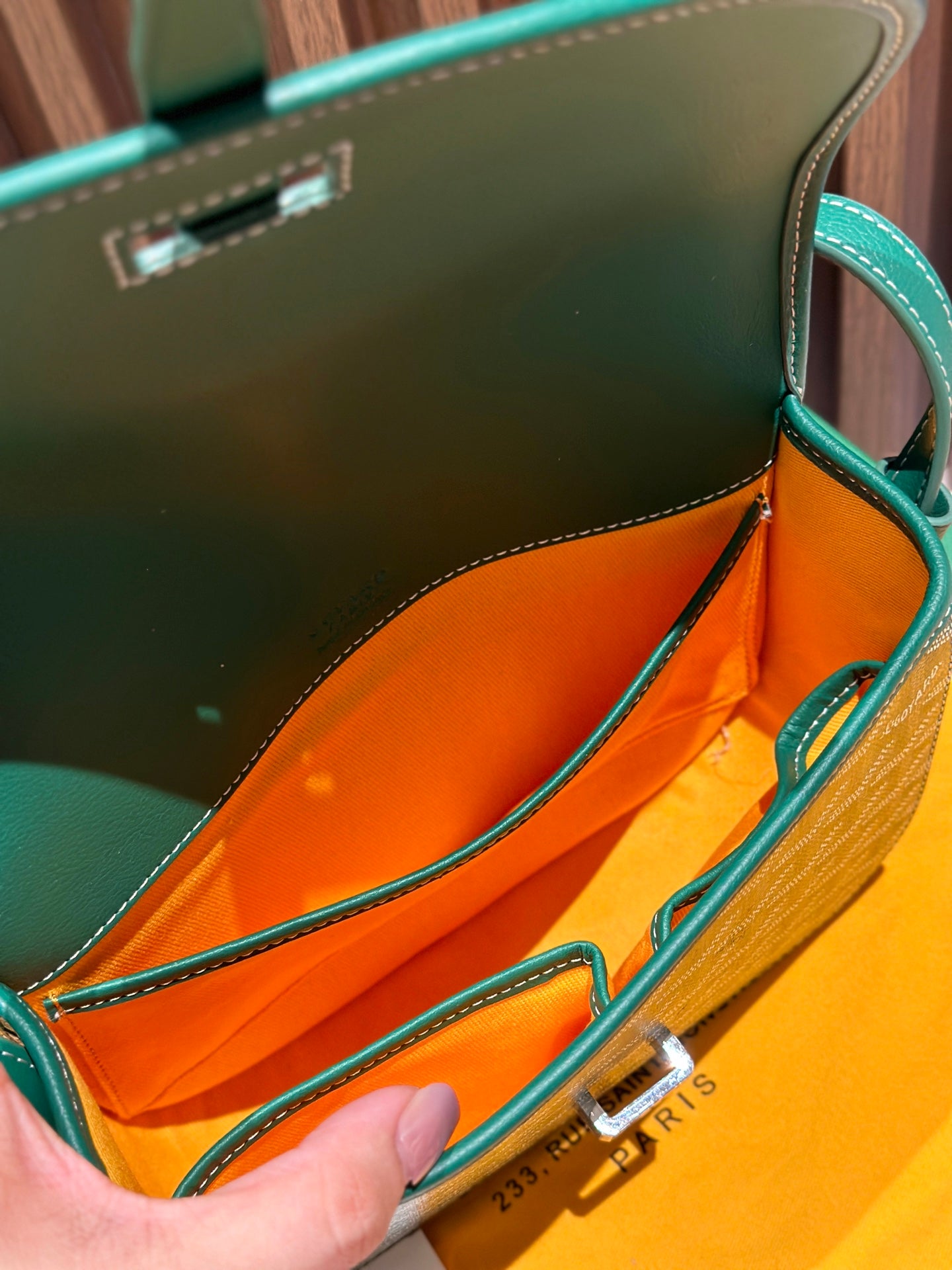 Goyard crossbody bag interior view with orange lining and leather edge trim