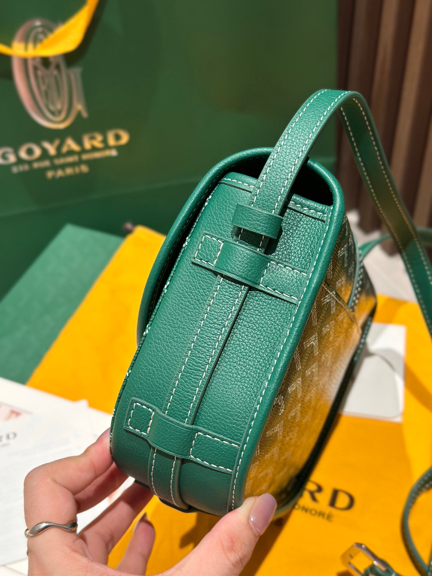 Goyard green leather crossbody bag with top handle, strap, and stitched seams
