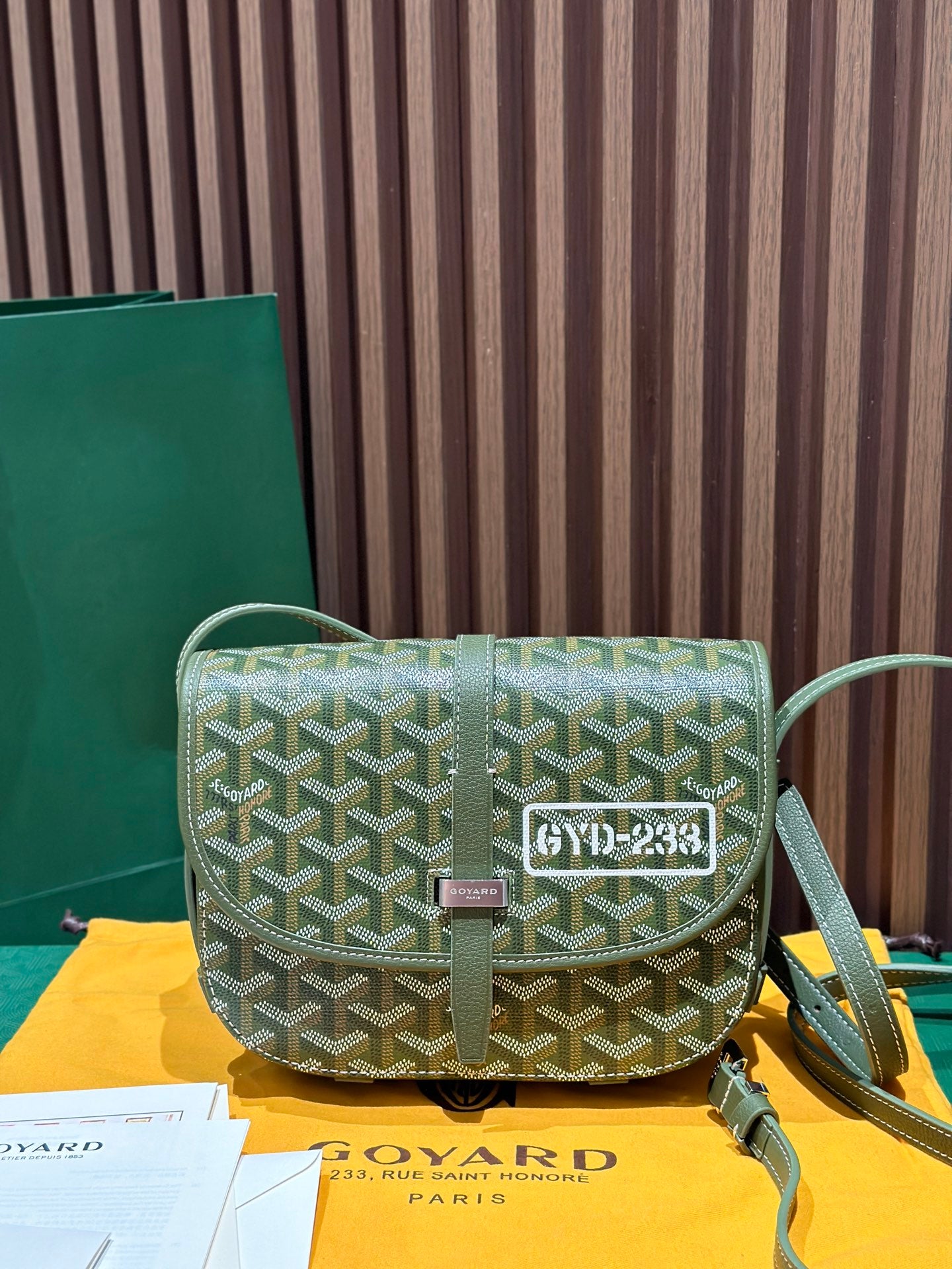 Goyardine crossbody bag in green with geometric pattern, flap, and adjustable shoulder strap.