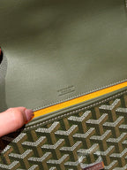 Embossed Goyard logo on olive leather corner trim with patterned canvas edge.