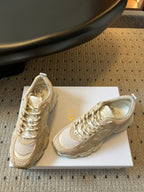 Dior unisex sneakers side view, cream uppers with gold stitching and lace hardware