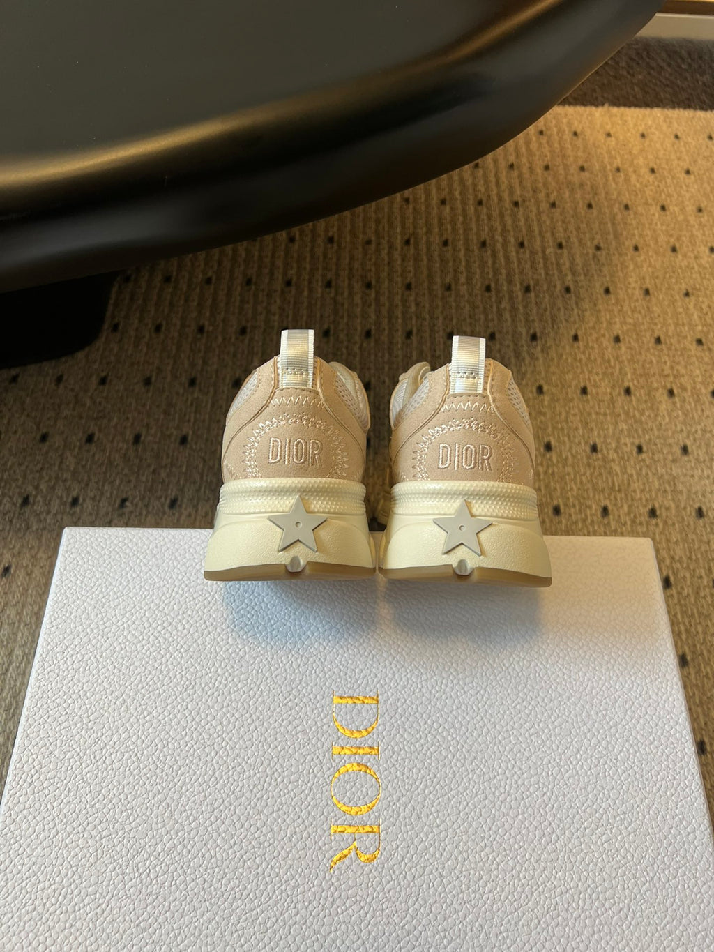 Dior unisex sneakers back view, cream heels with DIOR text and star accents