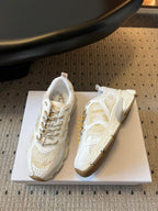 Dior unisex sneakers in white with gold accents, side view on box