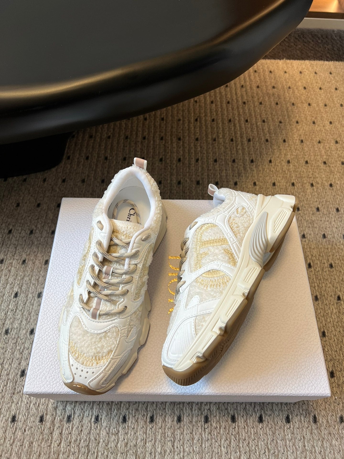 Dior unisex sneakers in white with gold accents, side view on box