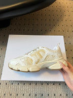 Dior unisex sneaker profile, white with gold stripe, cream sole with ridges