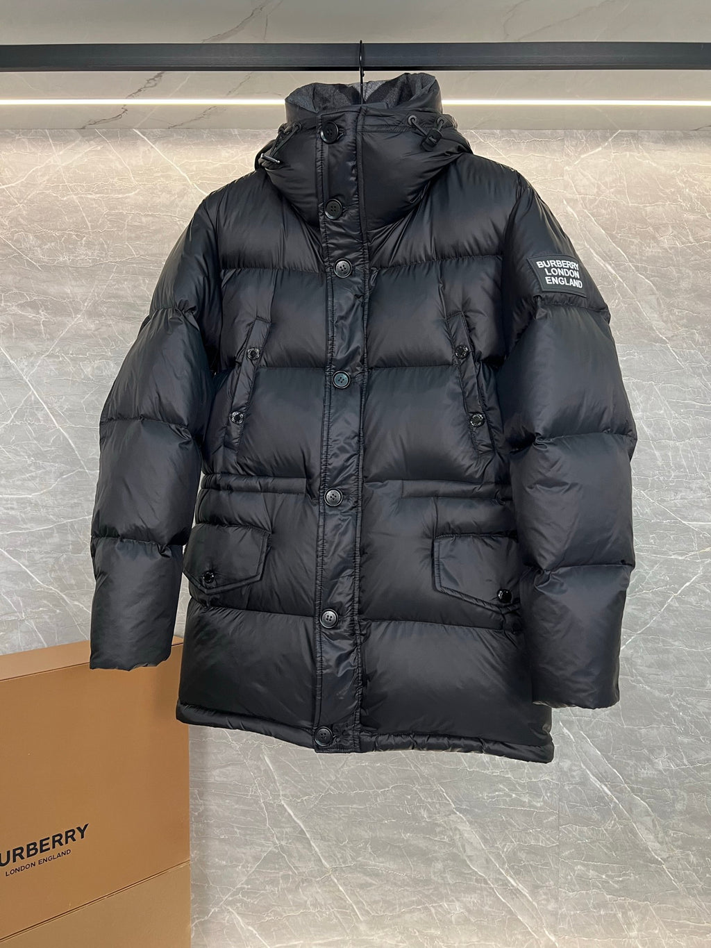 Dark long puffer jacket with hood, button front and flap pockets (logo patch sleeve)