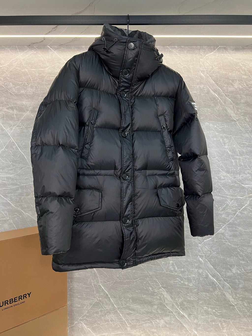 Burberry long hooded puffer jacket, dark quilted front with button closure and side pockets