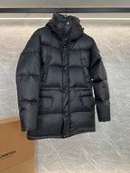 Dark long puffer jacket with hood, button front and flap pockets (side view)