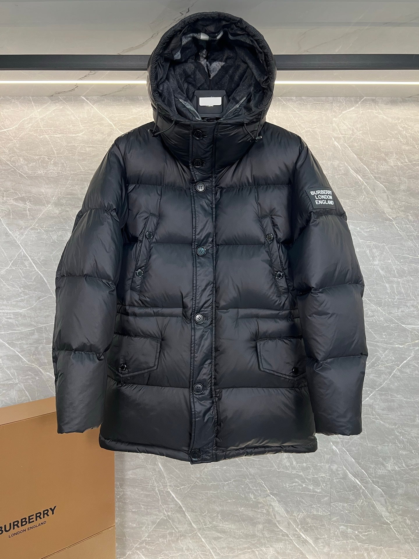 Burberry long hooded puffer jacket, dark quilted front with central button closure and patch pockets