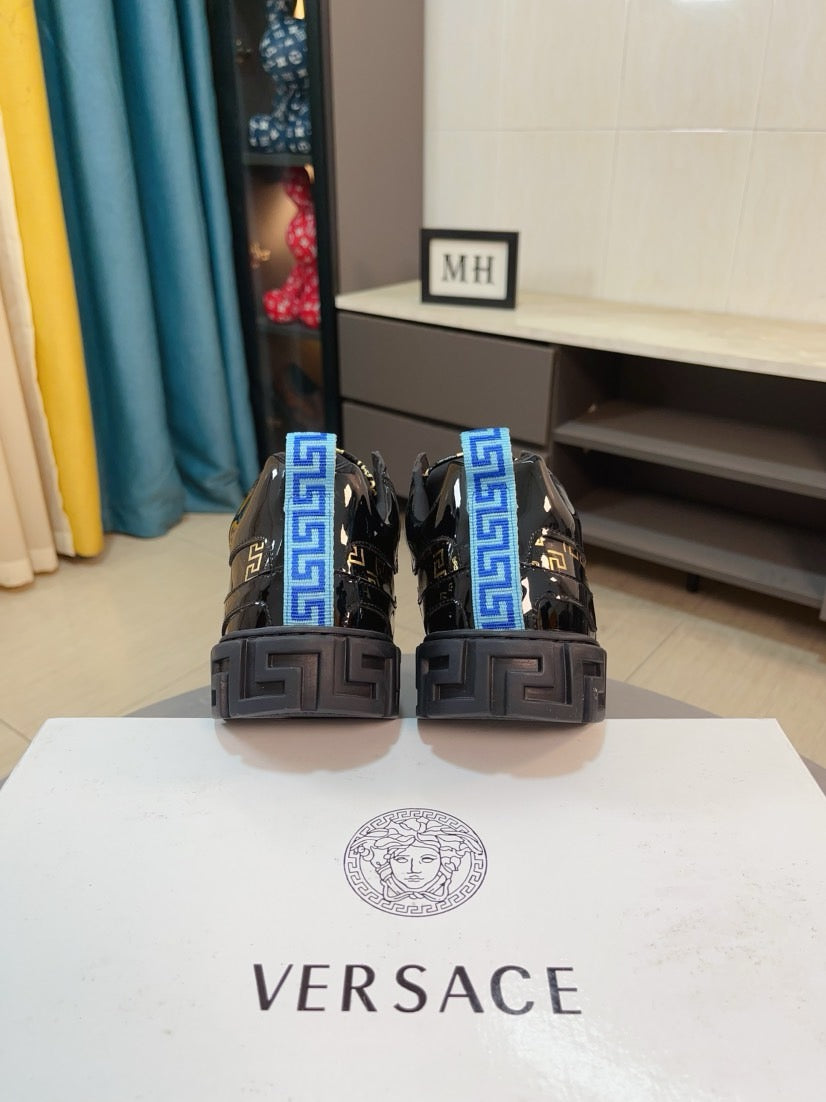 Pair of black Versace high-top sneakers with blue accents and chunky heel blocks