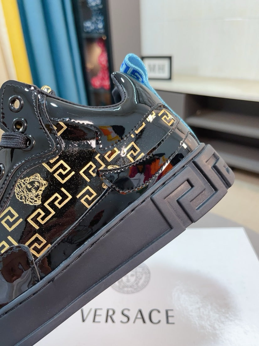 Black Versace high-top sneakers with gold Greca logos and chunky gray platform sole