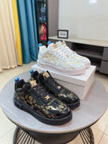 Versace sneakers display: one white and one black lace-up with logo trim on sides.