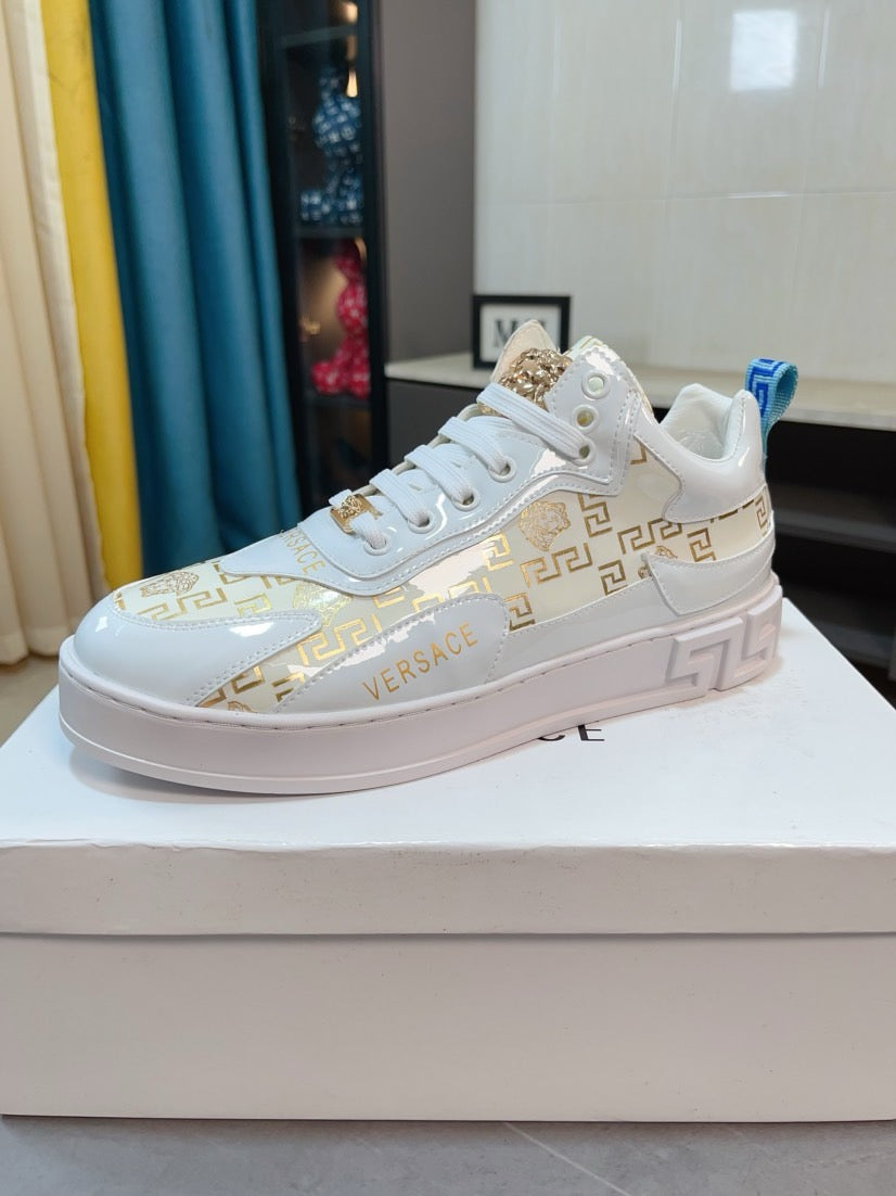 Versace white lace-up sneakers with gold patterned panel and blue heel pull tab.