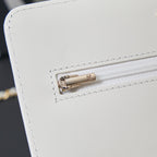 White Chanel bag close-up of gold-tone turn-lock clasp on front flap
