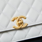 White quilted Chanel bag close-up of gold CC logo medallion on flap