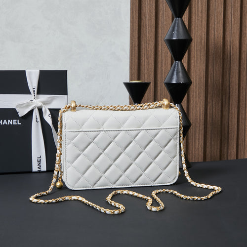 White quilted Chanel crossbody bag with gold chain strap draped across front