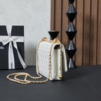 White quilted Chanel shoulder bag angled view with gold chain and back clasp