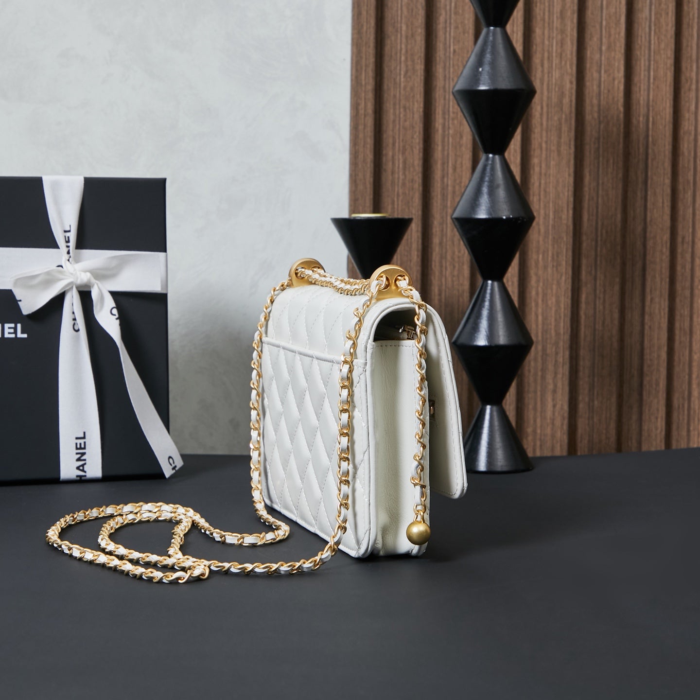 White quilted Chanel shoulder bag angled view with gold chain and back clasp