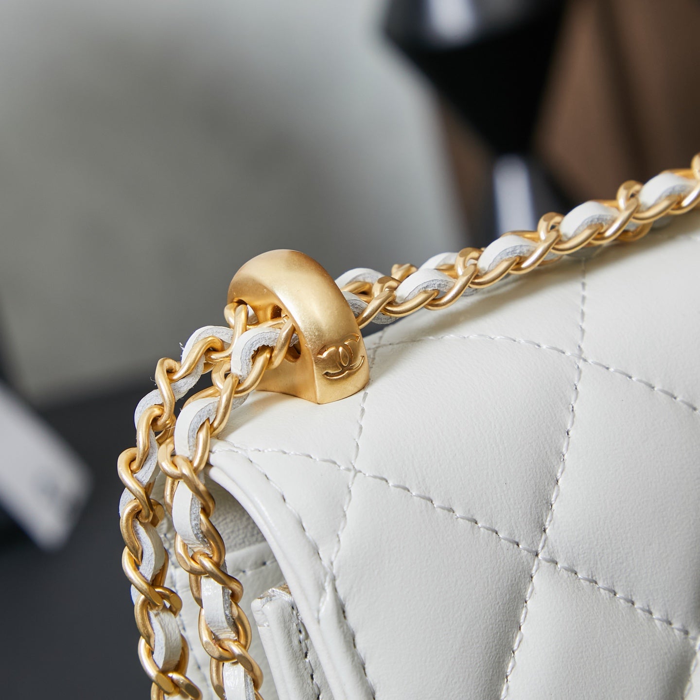 White quilted Chanel bag close-up of gold chain links attached to side