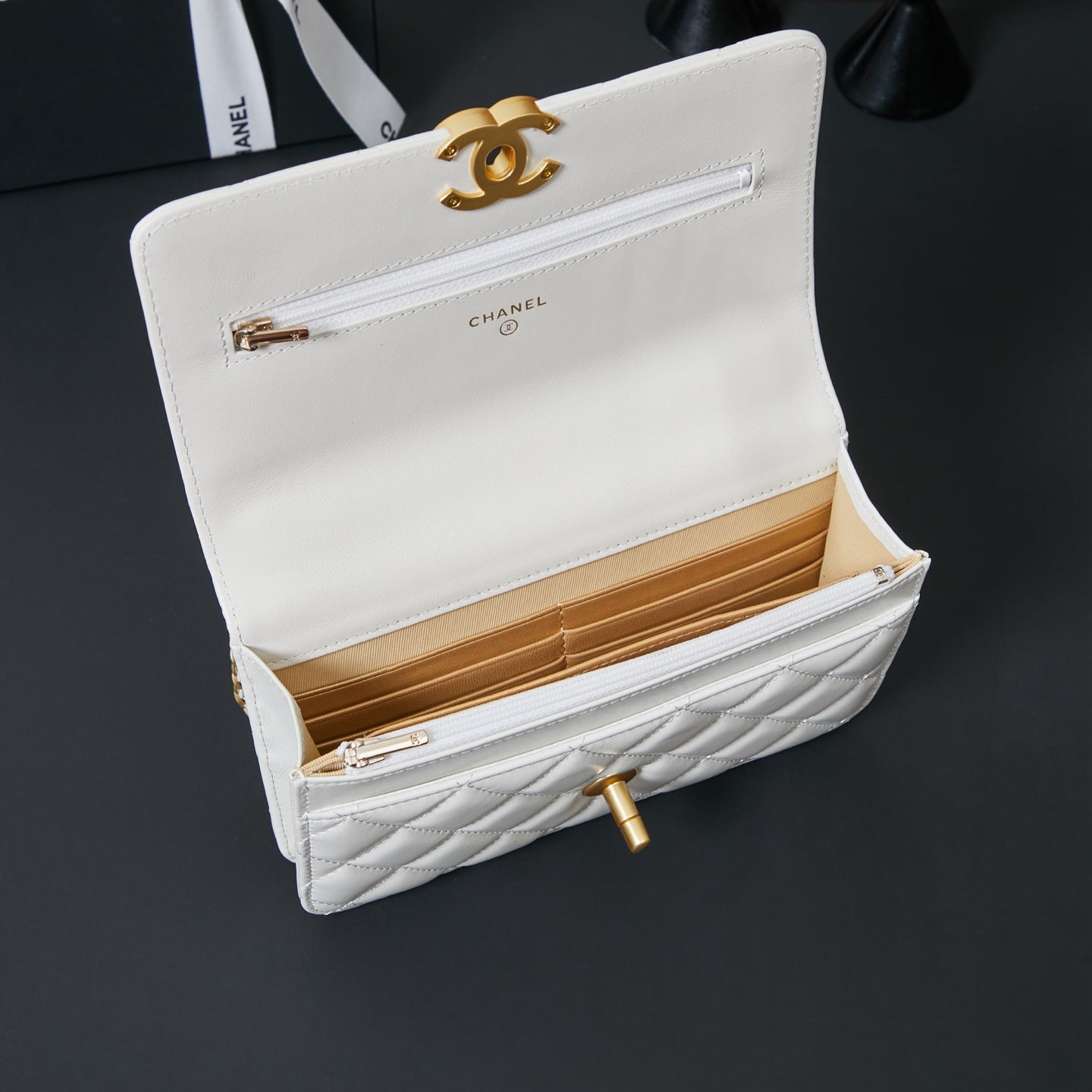 White Chanel bag open to show quilted interior and gold-tone hardware fastener