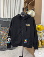 Black zip-up hoodie with chest logo patch and small rectangular badge