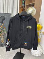 Black zip-up hoodie with front graphic patch, hood drawstring, and sleeve logo