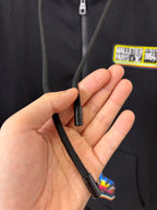 Black hoodie zipper pull and label, held in hand