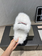 White fur slide sandal on box, hand holding front