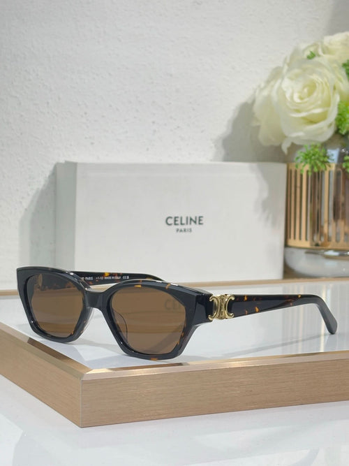 Black cat-eye sunglasses with gold logo detail and brown-tinted lenses on frame