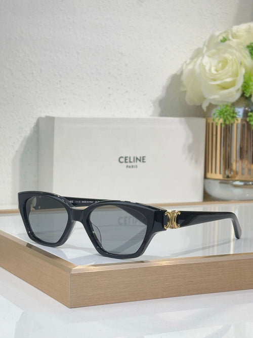 Black cat-eye sunglasses with gold logo detail and blue-tinted lenses on frame