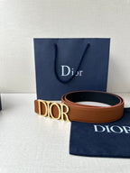 Tan leather Dior belt with engraved Dior buckle and visible strap edge.