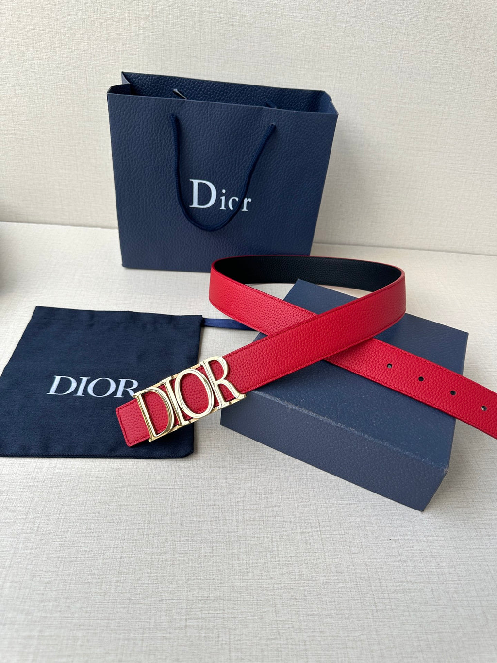 Dior red leather belt with gold-tone “DIOR” buckle and end holes