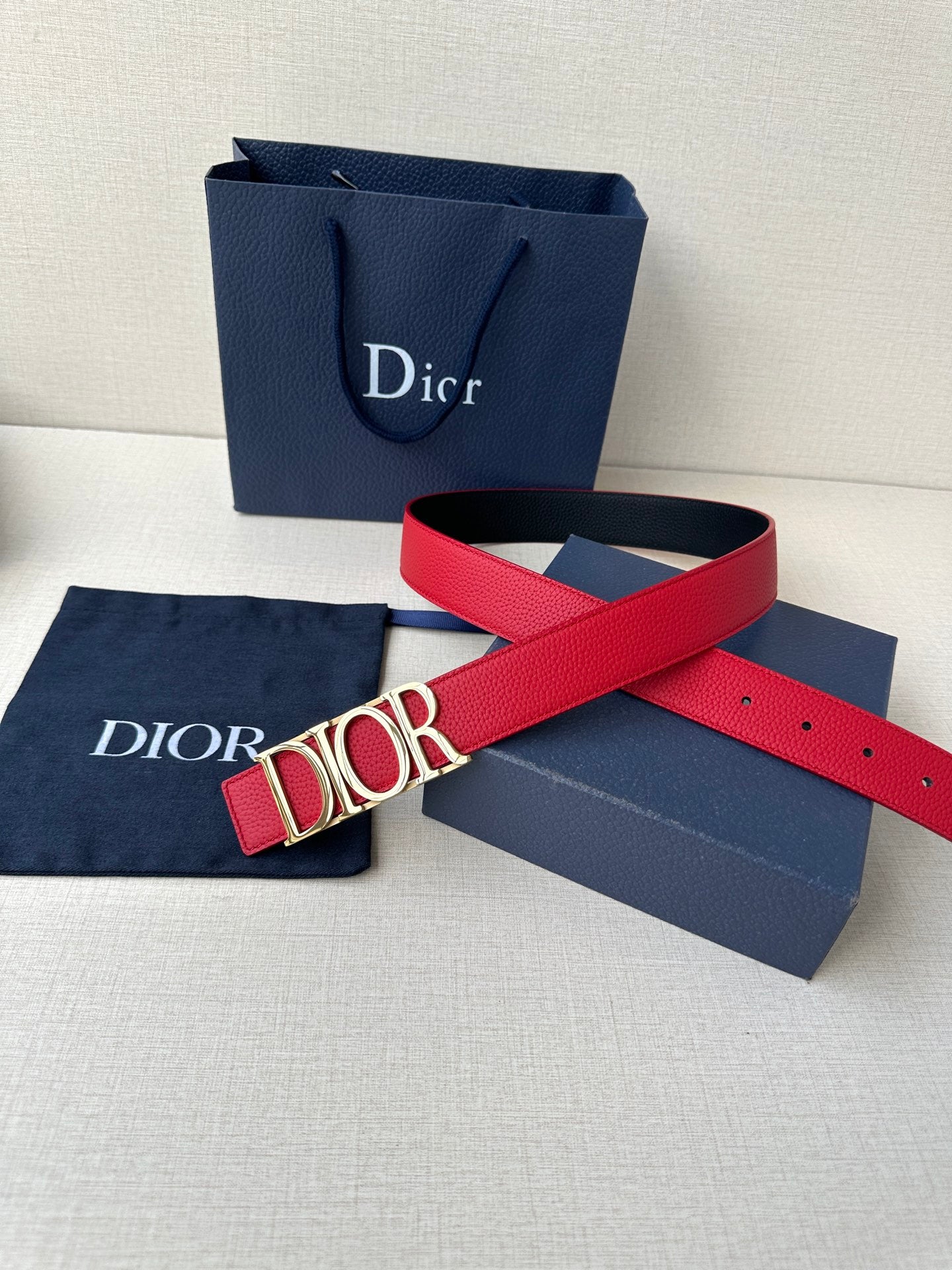 Dior red leather belt with gold-tone “DIOR” buckle and end holes