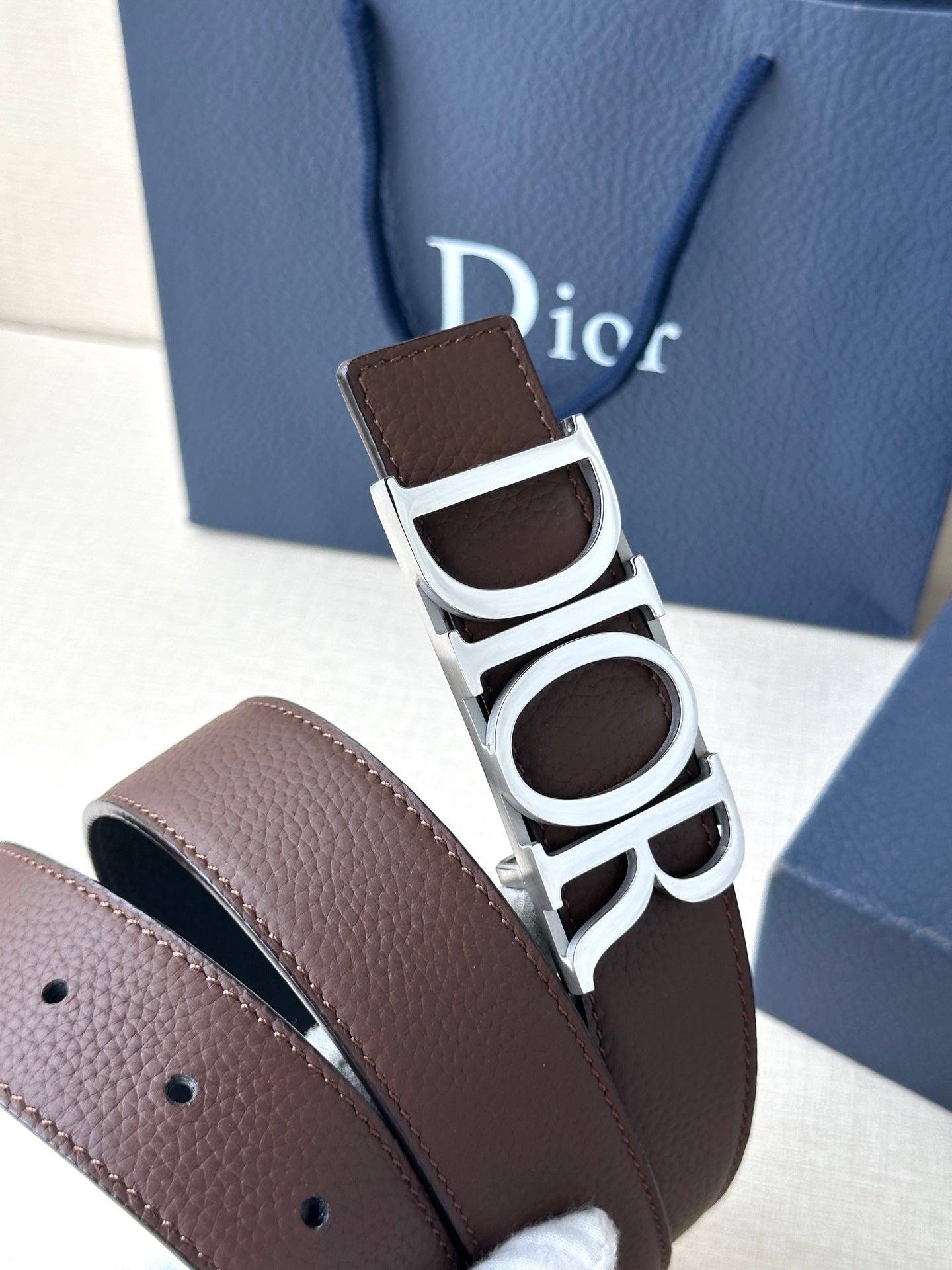 Brown leather belt with silver buckle and black inlay
