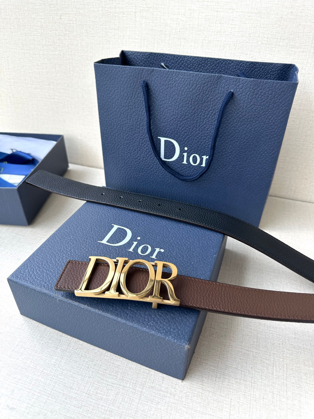 Brown leather belt with dark buckle and gold Dior lettering