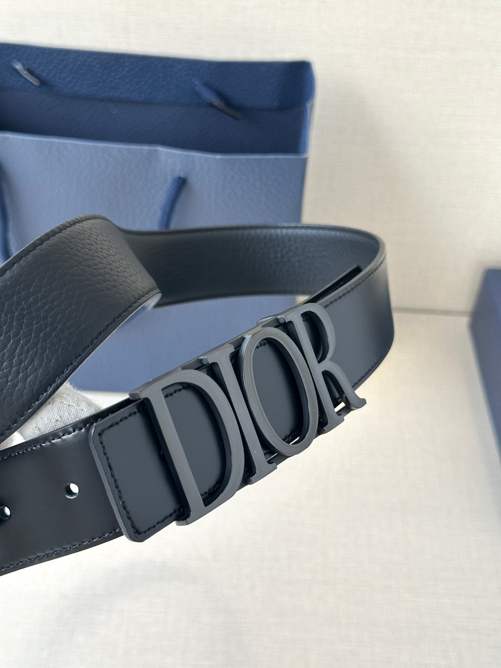 Black leather Dior belt with large Dior logo buckle and adjustable strap holes