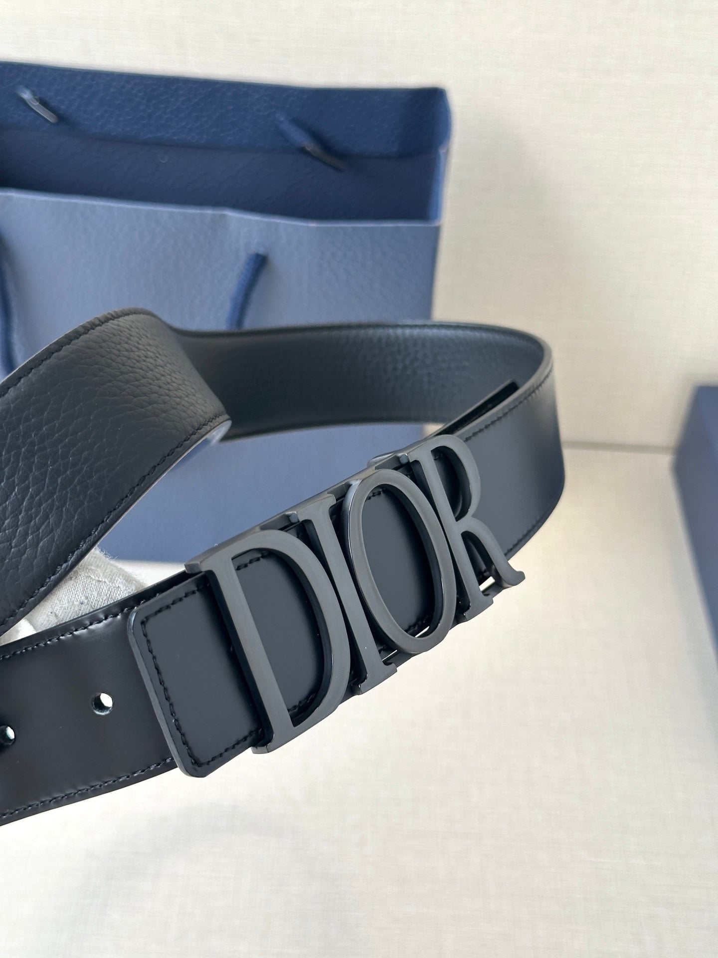 Black leather Dior belt with large Dior logo buckle and adjustable strap holes