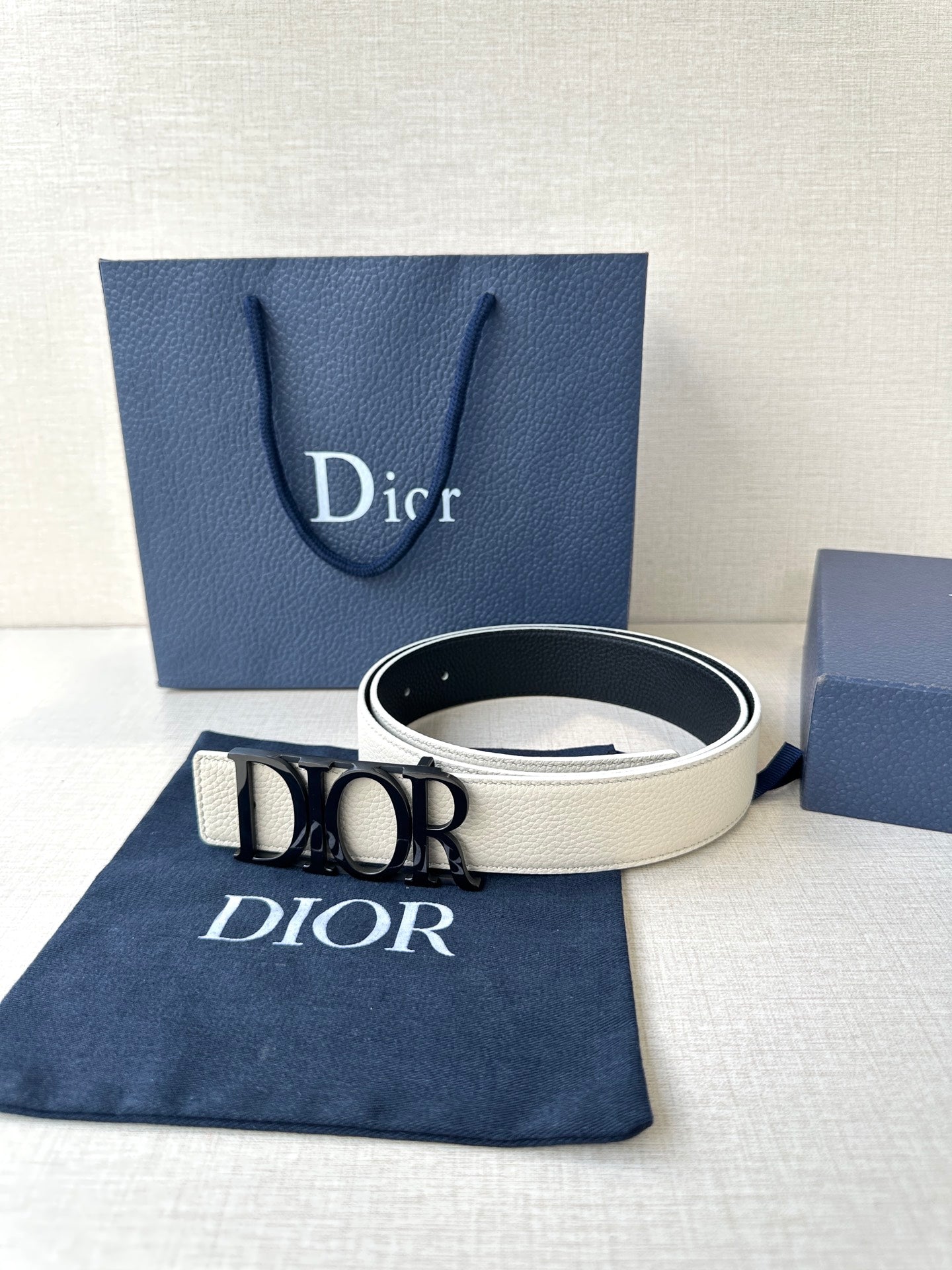 Dior white leather belt with gold-tone Dior buckle, lying flat