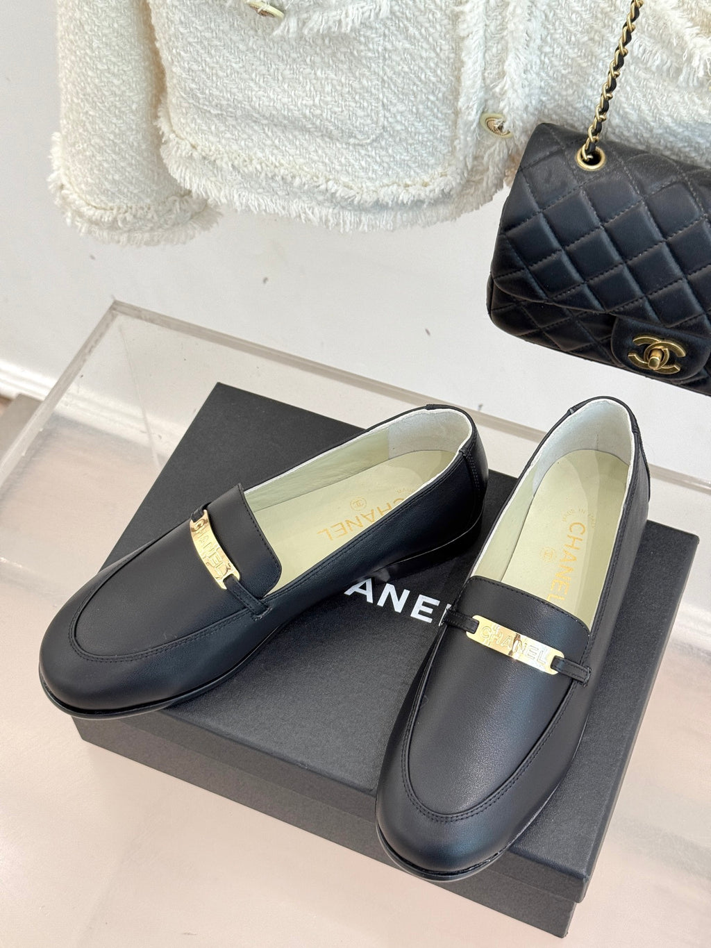 Black leather loafers with gold bar strap and pale insole, Chanel logo