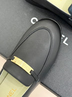 Black leather loafer with gold buckle bar strap and Chanel logo on strap