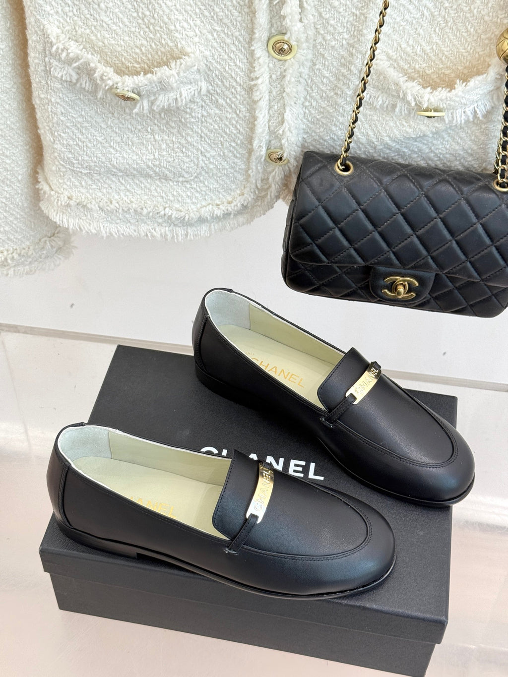Black leather loafer pair with gold buckle bar strap on low heel