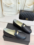 Black leather loafer pair with gold buckle bar strap on low heel