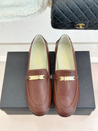 Women’s brown leather loafers with gold buckle bar, close front view pair