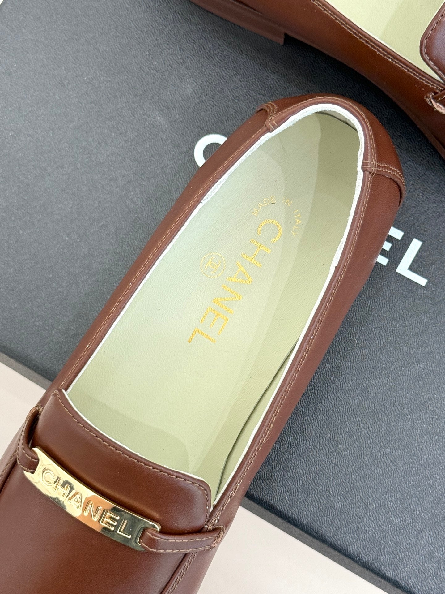 Women’s brown leather loafer showing light-colored insole with gold print